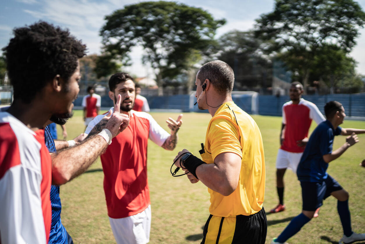 Soccer players complaining to referee during match